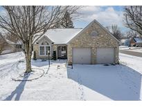 Charming stone-faced home with a two-car garage and a snow-covered lawn at 6751 Wild Cherry Dr, Fishers, IN 46038