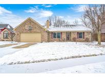 Charming brick home with a two-car garage and a basketball hoop on a winter day at 6820 Kirkwood Club Dr, Indianapolis, IN 46241