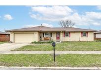 Charming ranch style home featuring a brick exterior, attached garage and well-manicured lawn at 7808 Crossgate Ln, Southport, IN 46227