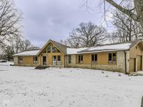 Spacious single-story home features a gable roof, multiple windows and a stone facade at 810 N Cherry Wood Ln, Muncie, IN 47304