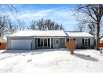Charming single-story home featuring a covered entryway, attached garage, and a snowy front yard at 935 Elmwood Cir, Noblesville, IN 46062