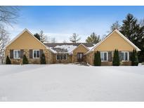 Charming stone home featuring gable roofs and a beautifully landscaped front yard covered in snow at 1011 Yellow Brick Rd, Pendleton, IN 46064
