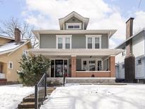 Charming two-story home with a covered front porch and well-maintained landscaping, perfect for enjoying the outdoors at 102 N Bosart Ave, Indianapolis, IN 46201