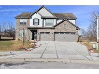 Inviting two-story home with a brick facade, spacious driveway, and attached two-car garage at 17443 Cavalcade Cir, Noblesville, IN 46060