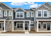 Charming townhome featuring stone accents, classic columns, and a welcoming black front door at 19517 Grassy Branch Rd, Westfield, IN 46074