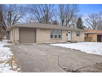 Charming one-story home featuring a stone facade, attached garage, and concrete driveway at 313 Lawndale Dr, Plainfield, IN 46168
