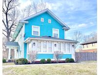Charming two-story turquoise home with a bright sunroom and beautifully landscaped front yard at 3236 Central Ave, Indianapolis, IN 46205