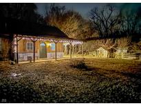 Charming home exterior illuminated with string lights, featuring a covered porch and rustic shed at 4516 Ridge Rd, Anderson, IN 46013