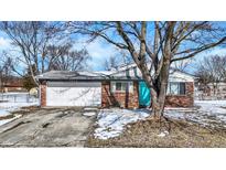 Charming brick home features an attached garage, and a pop of color with the bright blue front door at 5614 Personality Ct, Indianapolis, IN 46237