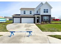Two-story home featuring a brick and siding facade, two-car garage, and a well-manicured front lawn at 5879 Handbell Ln, Greenwood, IN 46143