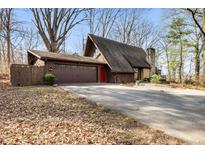 Charming A-frame home with brown siding, two car garage, stone chimney, and eye-catching red front door at 671 State Road 267, Mooresville, IN 46158