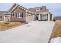 Charming single-Gathering home features a brick and siding exterior and a large concrete driveway at 8660 Hudson Way, Brownsburg, IN 46112