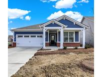 Charming blue home featuring a brick accent, white trim, a pristine driveway, and a two car garage at 9401 Corbett Dr, McCordsville, IN 46055