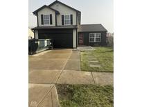 Charming two-story home featuring a black painted garage, complemented by a well-maintained front lawn at 1013 Redwood Dr, Lebanon, IN 46052