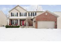 Charming two-story home with a brick facade and covered front porch amidst a snow-covered lawn at 1251 Softwind Dr, Indianapolis, IN 46260