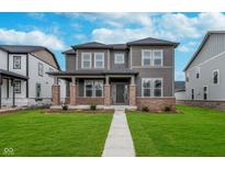 Beautiful two-story home features a manicured lawn, brick accents, and a welcoming front porch at 14390 Bishop Birch Pl, Carmel, IN 46032