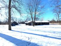 Front exterior of home with snow covered yard and an outbuilding at 401 W Edwards Ave, Indianapolis, IN 46217