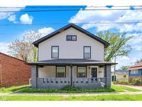 Two-story home featuring a covered porch and a well-maintained lawn at 5053 E Michigan St, Indianapolis, IN 46201