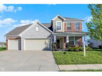 Charming two-story home features a blend of brick and stone, with a two car garage, and a well manicured lawn at 5648 Juniper Ct, Whitestown, IN 46075