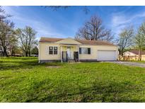 Charming one-story home with an attached garage and a well-manicured front yard at 5757 E 21St St, Indianapolis, IN 46218