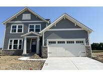 Two-story home with a gray siding, stone accents, white trim, and a two-car garage at 618 Firefly Ct, Greenfield, IN 46140