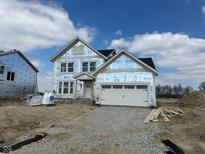 New construction two-story home featuring a two-car garage, visible framing, and covered with protective wrap awaiting final exterior at 618 Firefly Ct, Greenfield, IN 46140