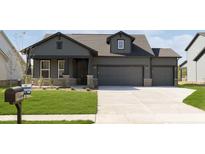 Craftsman style home with dark siding, brick accents, well-manicured lawn and three car garage at 7038 Barrett Dr, Brownsburg, IN 46112