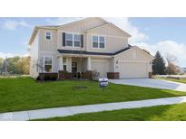 Charming two-story home boasts manicured lawn, neutral siding, and attached two car garage at 7197 Barrett Dr, Brownsburg, IN 46112