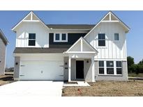 Charming two-story home featuring white siding, dark accents, a two-car garage, and manicured front yard at 750 Oakleaf Dr, Greenfield, IN 46140