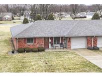 Charming red brick townhouse with a well-maintained lawn and attached garage at 120 Saratoga Way, Anderson, IN 46013