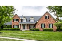 Charming brick home with a well-manicured lawn and lush landscaping at 13631 Singletree Ct, Carmel, IN 46032