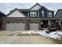 Charming two-story home featuring a two-car garage, brick facade, and blue siding at 1986 Mccormick Dr, Greenwood, IN 46143