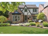 Charming two-story home with a well-manicured lawn and beautiful landscaping at 219 Buckingham Dr, Indianapolis, IN 46208