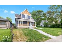 Charming two-story home with a well-manicured front lawn and inviting porch at 2257 E Brookside Ave, Indianapolis, IN 46218