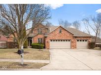 Charming brick home boasts a three-car garage and well-maintained landscaping at 2487 Wayward Wind Dr, Indianapolis, IN 46239