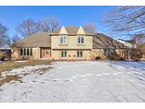 Two-story home featuring brick and siding exterior with a well-manicured lawn and inviting orange front door at 2489 Woodsway Dr, Greenwood, IN 46143