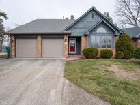 Charming single-story home featuring a brick facade, two-car garage, and well-maintained landscaping at 3441 Hickory E Ln, Indianapolis, IN 46214