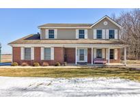 Charming two-story home boasts a brick facade, covered porch, and classic white shutters at 3492 S 600 W, Anderson, IN 46011