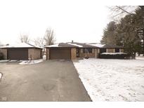 Inviting exterior of a ranch-style home featuring a brick facade, attached garage, and snow-dusted driveway at 3850 N County Road 575 E, Brownsburg, IN 46112