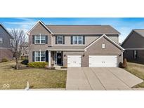 Charming two-story home featuring a brick and siding exterior, a two-car garage, and a well-manicured front lawn at 5556 W Compass Pt, McCordsville, IN 46055