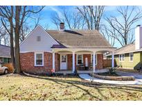 Charming brick home featuring a covered front porch with classic white columns and walkway at 5860 Indianola Ave, Indianapolis, IN 46220