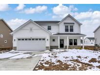Inviting two-story home with white siding, attached two-car garage, and stone accents, set against a blue sky at 7161 Jackson Dr, Cumberland, IN 46229