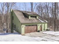 View of a two-story home with a drive in garage, and a snow covered yard at 1032 E Woodall Ct, Martinsville, IN 46151