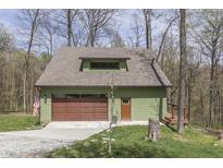 A rustic garage with a loft, featuring an automatic roll-up door at 1032 E Woodall Ct, Martinsville, IN 46151