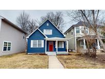 Charming two-story blue home with white trim, red door and a cozy front porch at 1038 W 33Rd St, Indianapolis, IN 46208