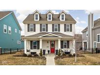 Charming three-story home with a red front door, dormer windows, and a landscaped front yard at 15432 Heatherbank Dr, Westfield, IN 46074