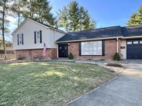 Charming two-story home featuring a well-manicured front lawn and an inviting brick facade at 3515 Autumn Ct, Columbus, IN 47203
