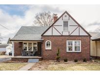 Charming brick Tudor-style home with a covered front porch and manicured landscaping at 6189 Primrose Ave, Indianapolis, IN 46220