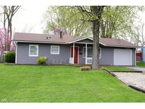 Charming single-story home with gray siding, red door, and well-maintained front yard at 724 Center St, Franklin, IN 46131