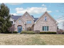 Charming brick home featuring an arched doorway, well-manicured lawn and beautiful windows at 9956 Hickory Ridge Dr, Zionsville, IN 46077